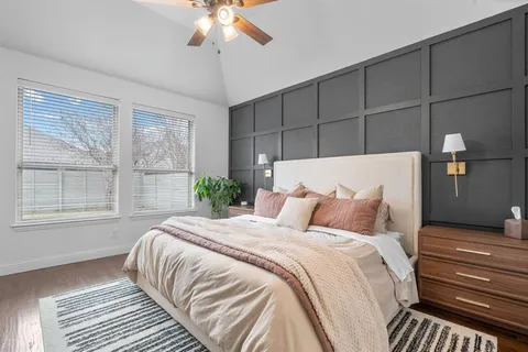 a bedroom with a large bed and a chandelier