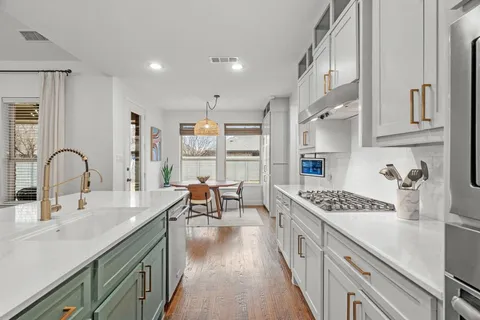 a kitchen with stainless steel appliances granite countertop a sink stove and cabinets