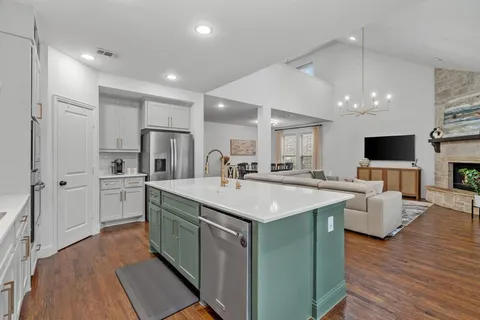 a kitchen with white cabinets sink and stainless steel appliances