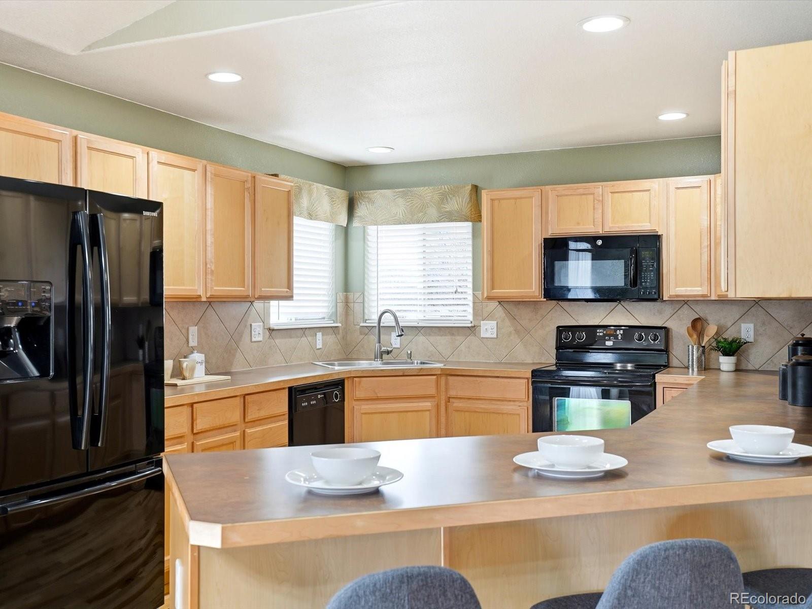 9720 Roadrunner Avenue Firestone, CO 80504 - Photo 11 of 46 a kitchen with stainless steel appliances granite countertop a refrigerator a stove top oven a sink and dishwasher