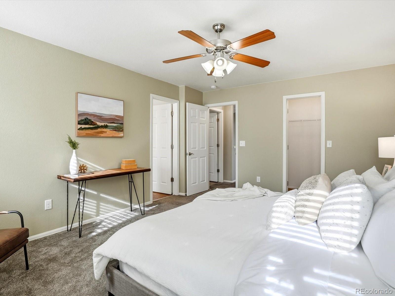 9720 Roadrunner Avenue Firestone, CO 80504 - Photo 16 of 46 a bedroom with a bed and a chandelier