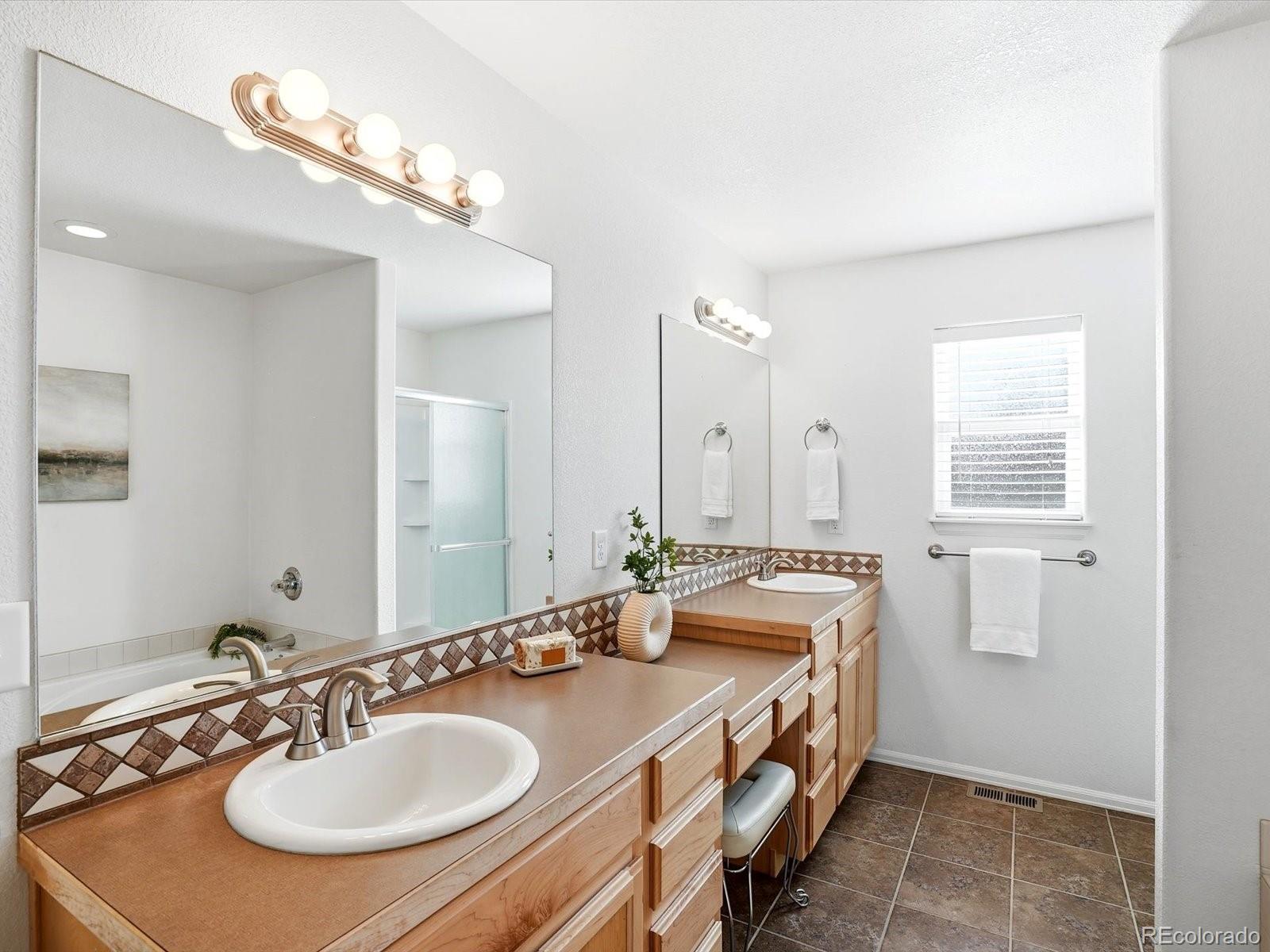 9720 Roadrunner Avenue Firestone, CO 80504 - Photo 17 of 46 a bathroom with a sink double vanity and a mirror