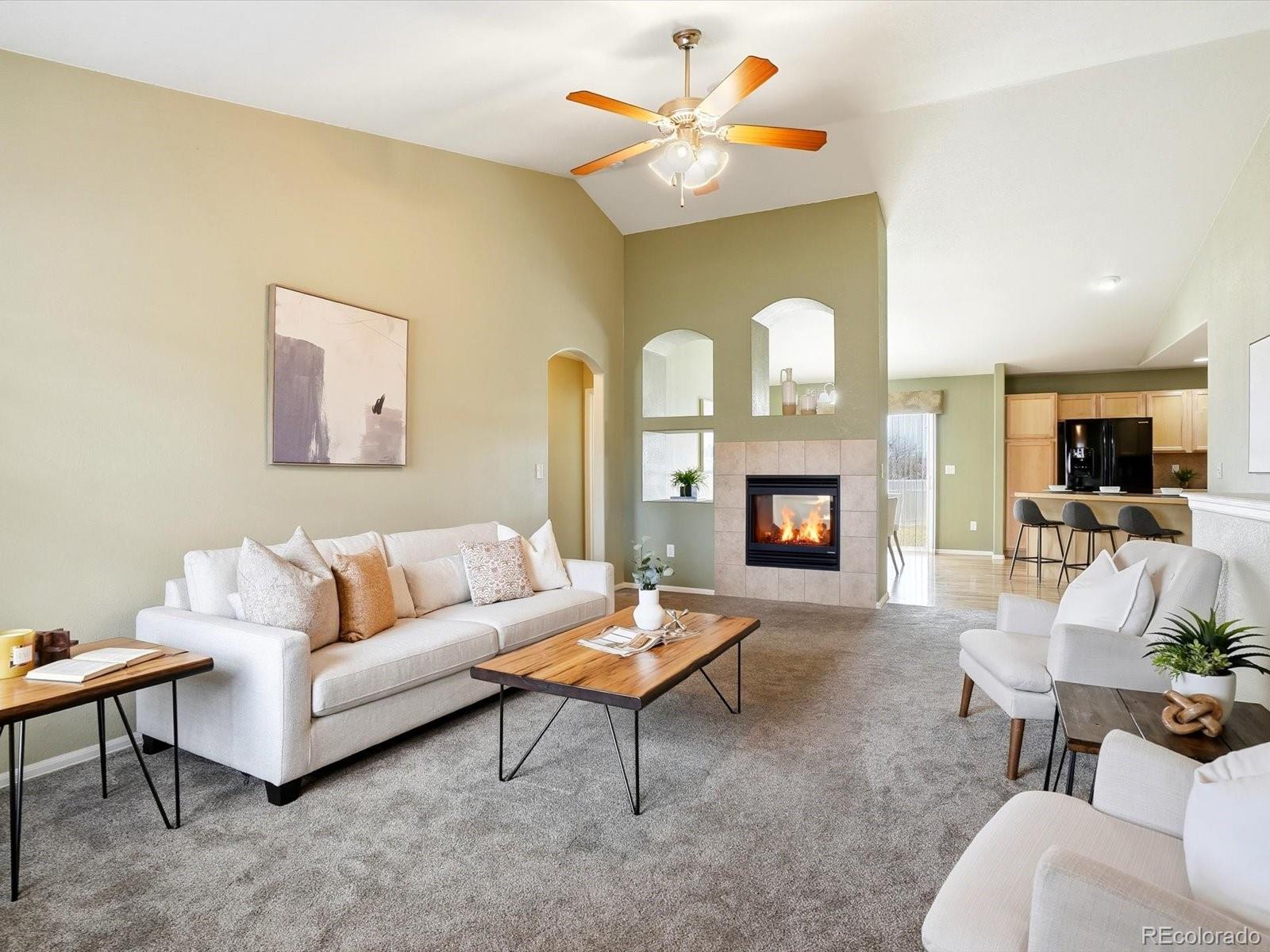 9720 Roadrunner Avenue Firestone, CO 80504 - Photo 7 of 46 a living room with furniture a fireplace and a flat screen tv