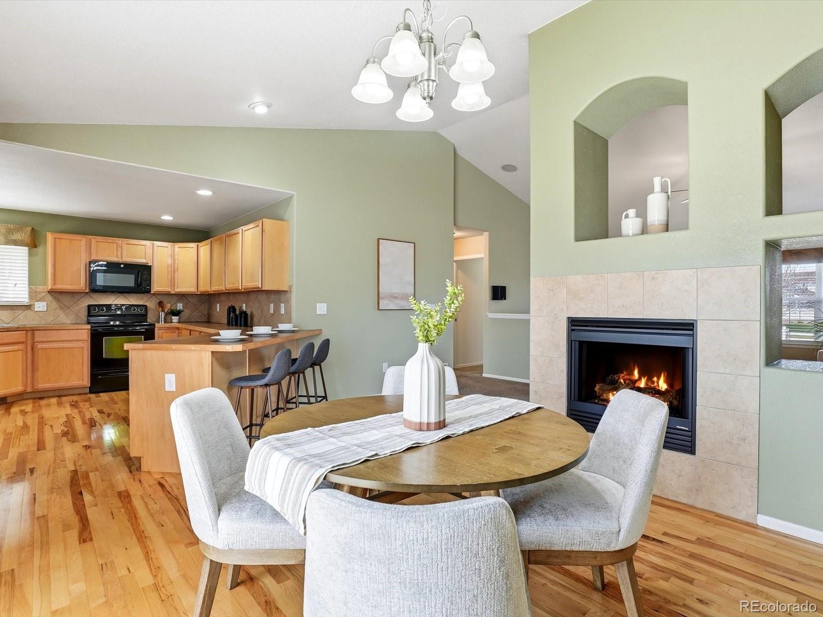 9720 Roadrunner Avenue Firestone, CO 80504 - Photo 8 of 46 a dining room with furniture a fireplace and wooden floor