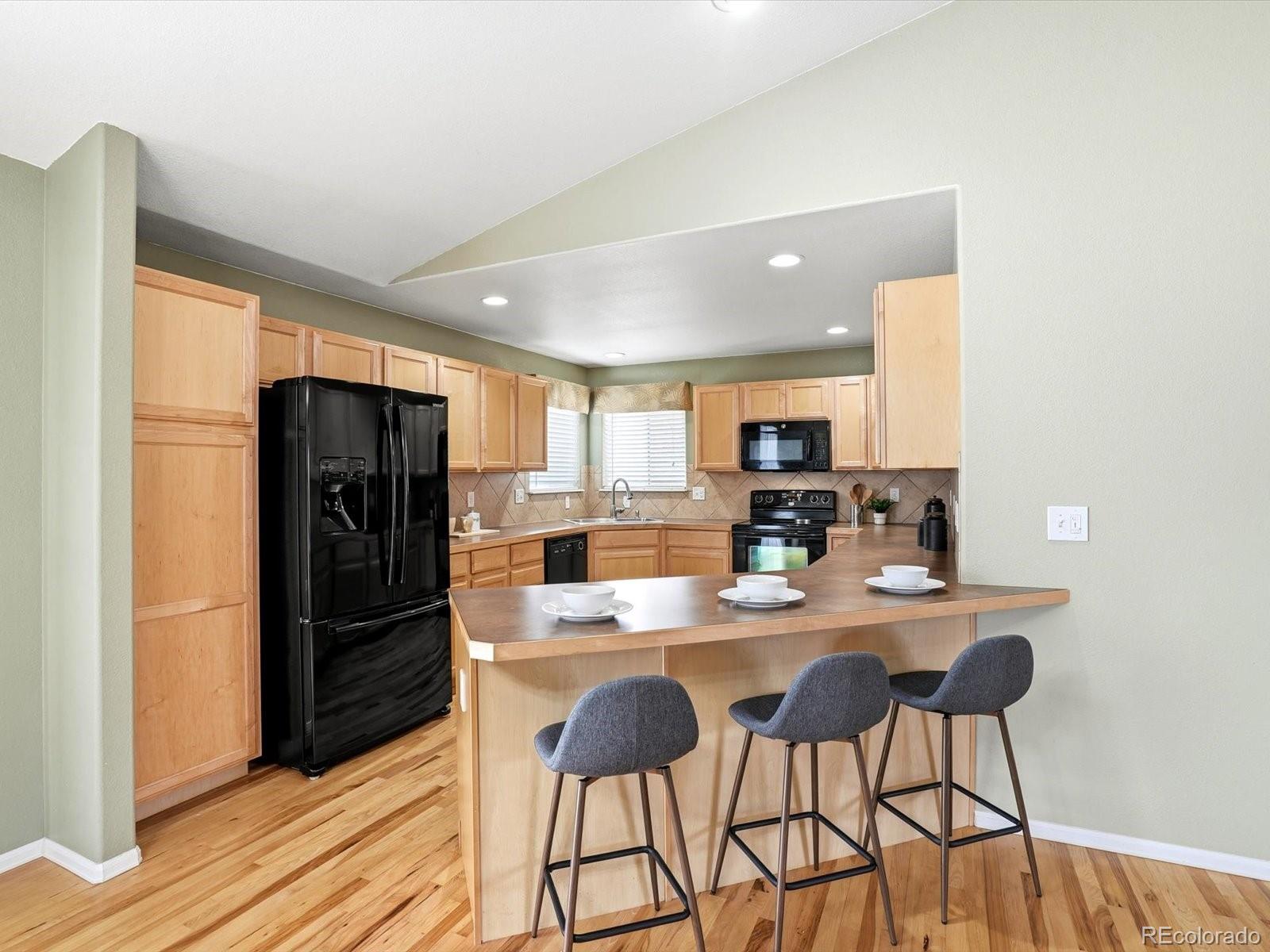 9720 Roadrunner Avenue Firestone, CO 80504 - Photo 9 of 46 a kitchen with stainless steel appliances granite countertop a refrigerator and a stove top oven