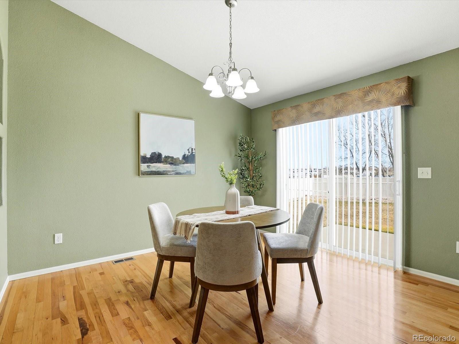 9720 Roadrunner Avenue Firestone, CO 80504 - Photo 10 of 46 a view of a dining room with furniture a chandelier and wooden floor
