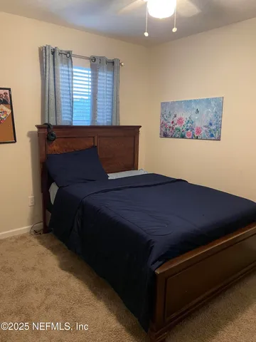 a bed sitting in a bedroom next to a window