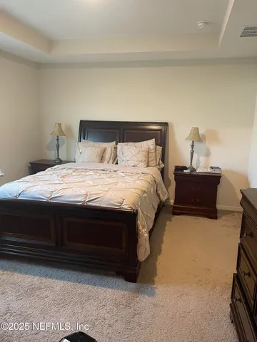 a bedroom with a bed and a lamp on dresser