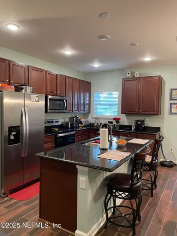 a kitchen with stainless steel appliances granite countertop a refrigerator and a stove top oven