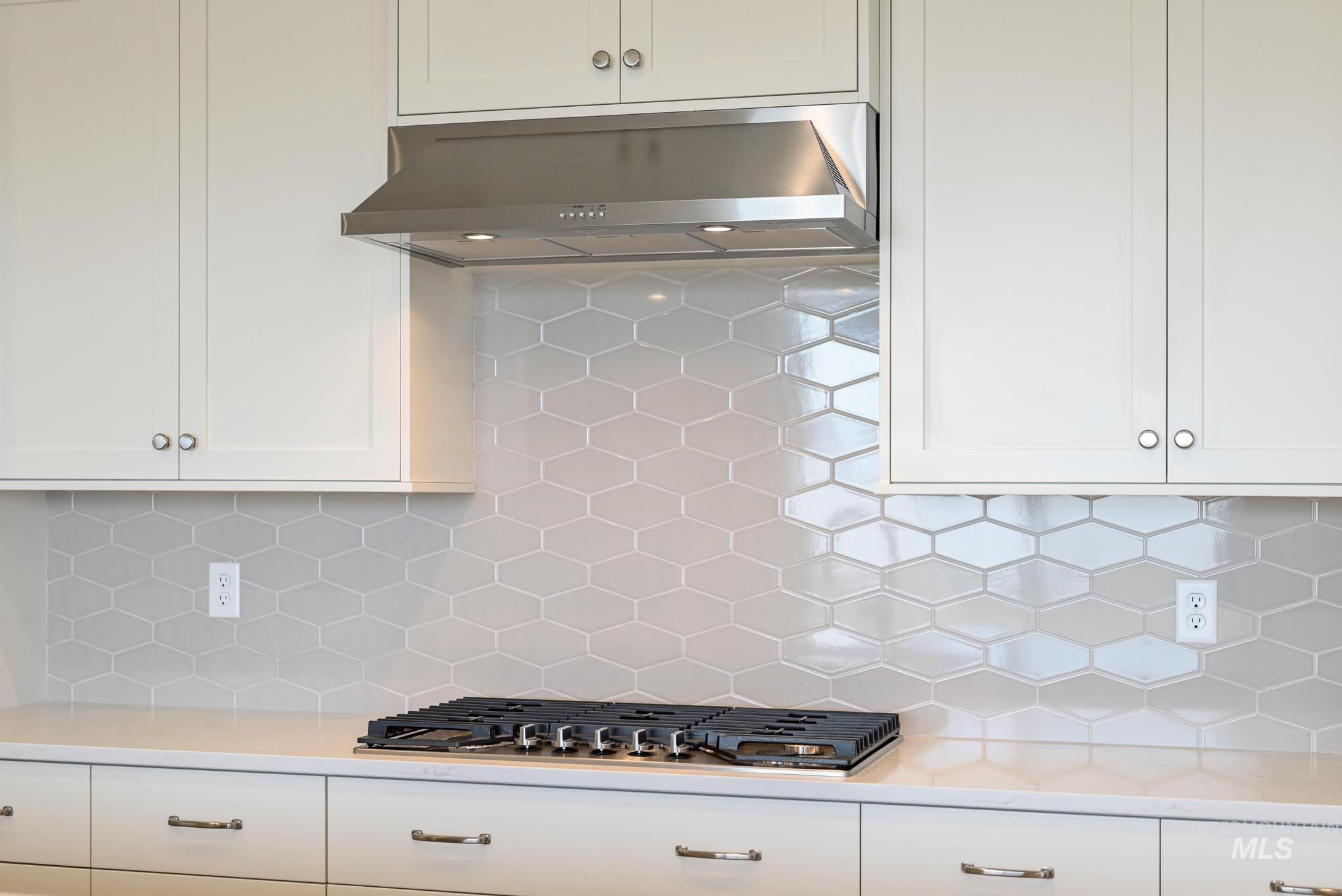 8501 South Country Wind Avenue Meridian, ID 83642 - Photo 12 of 39 Kitchen featuring white cabinetry, decorative backsplash, light stone counters, and stainless steel gas stovetop