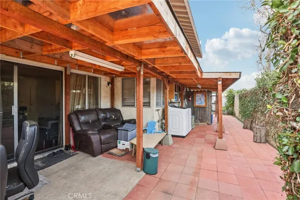a patio with a table and chairs under an umbrella