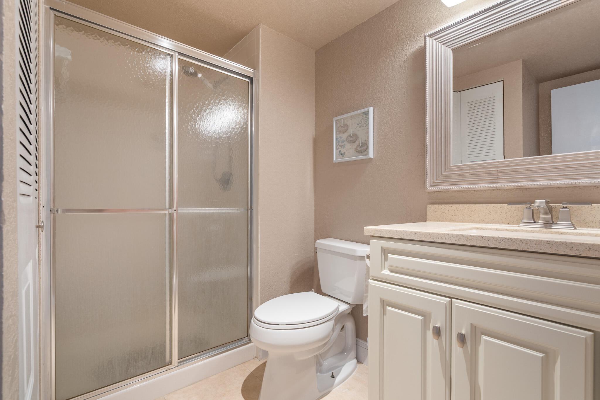 21218 Lago Circle, Unit F Boca Raton, FL 33433 - Photo 30 of 40 a bathroom with a toilet a sink and shower