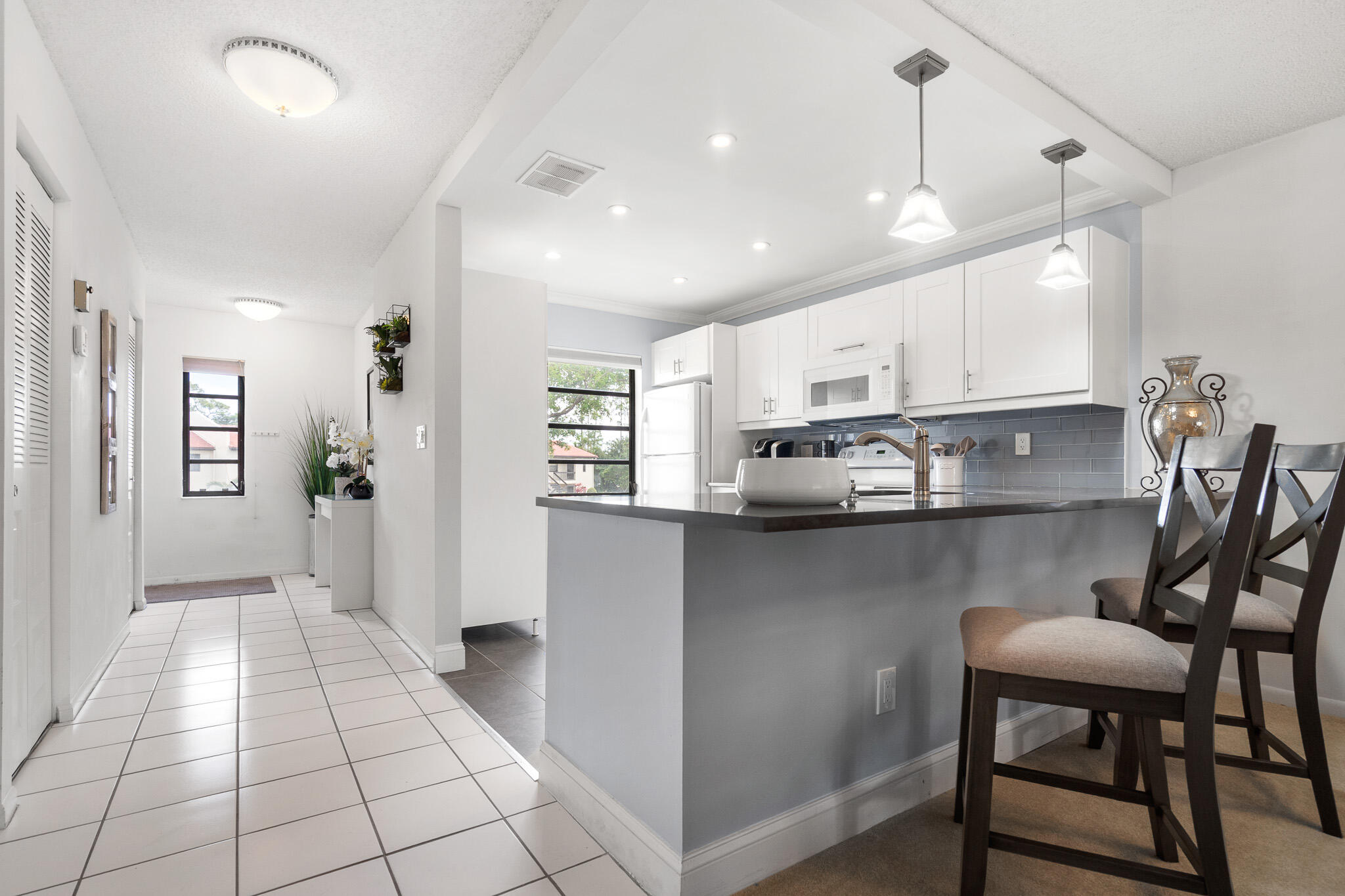 21218 Lago Circle, Unit F Boca Raton, FL 33433 - Photo 10 of 40 a kitchen with stainless steel appliances granite countertop a stove a sink and a refrigerator
