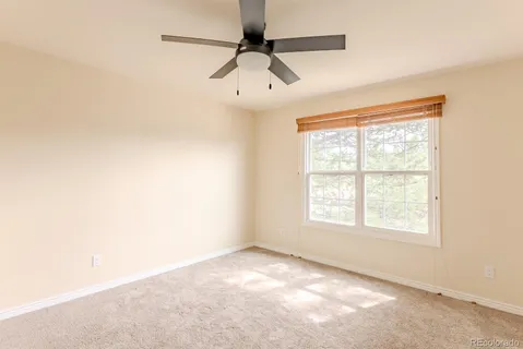 an empty room with a window and a fan
