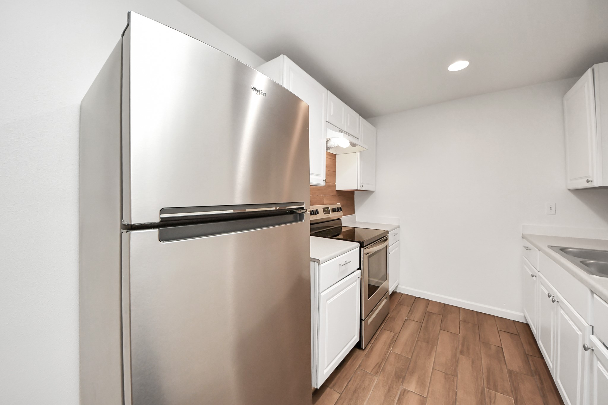 12068 Beechnut Street, Unit C Houston, TX 77072 - Photo 14 of 40 a kitchen with a refrigerator and white cabinets