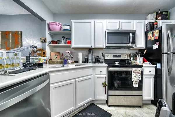 a kitchen with stainless steel appliances a stove and cabinets