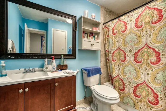 a bathroom with a toilet sink and mirror