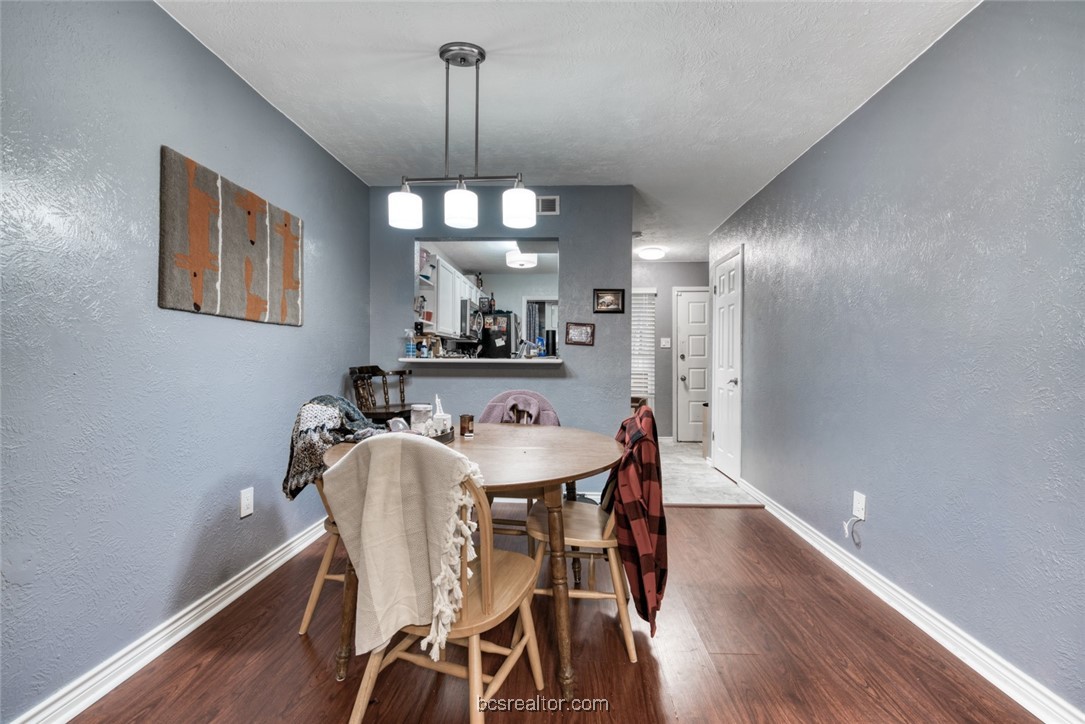 3802 College Main Street, Unit 12 Bryan, TX 77801 - Photo 5 of 11 a view of a dining room with furniture wooden floor and chandelier
