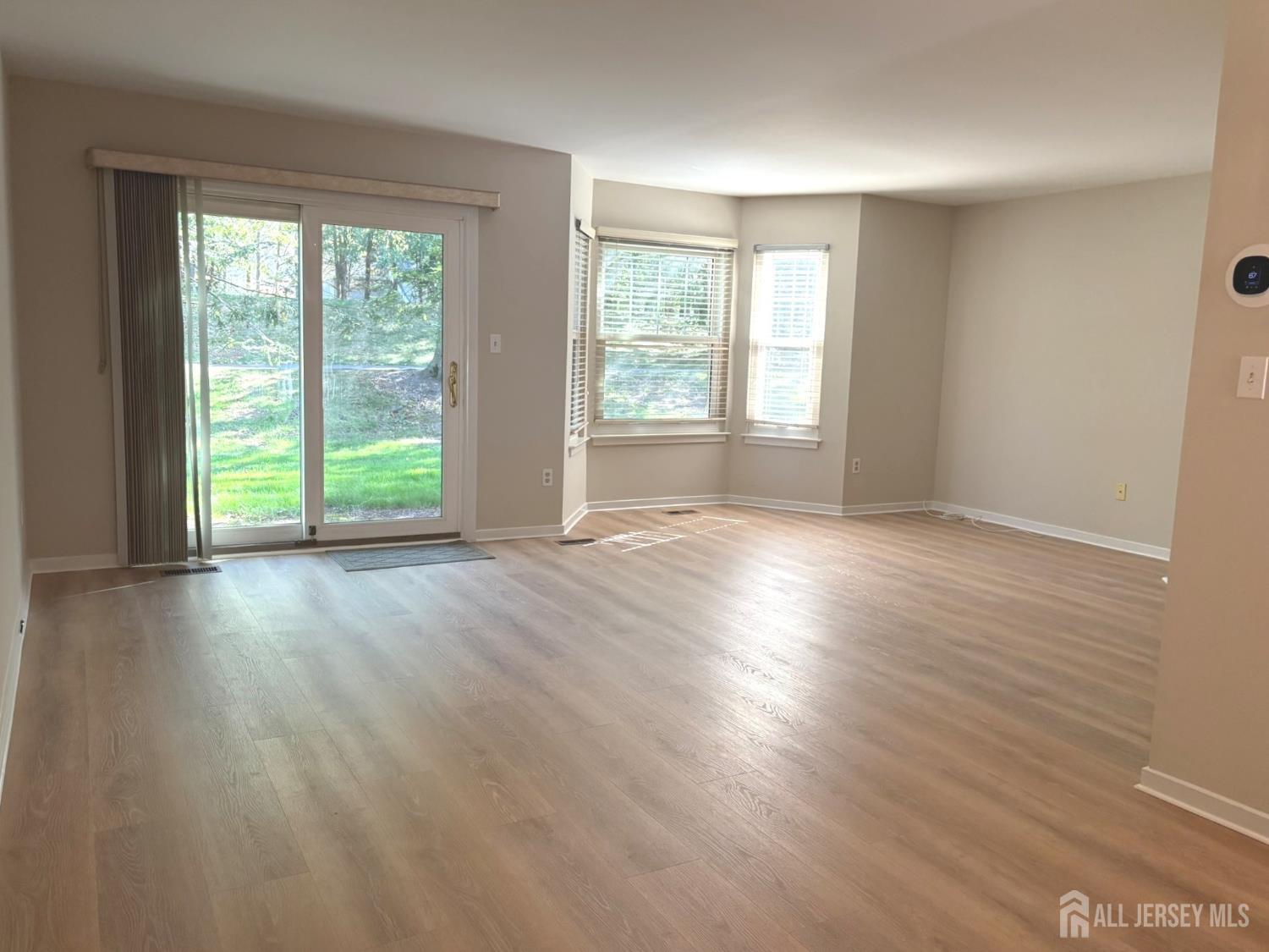 285 Greenfield Road Bridgewater, NJ 08807 - Photo 4 of 26 an empty room with wooden floor and windows