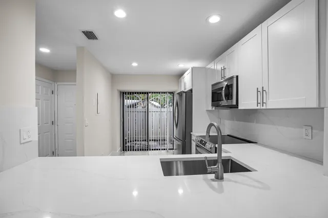 a kitchen with stainless steel appliances a sink stove and cabinets