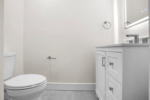 a bathroom with a toilet a sink a mirror and shower