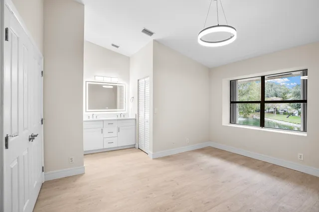 a view of an empty room with a window and a bathroom