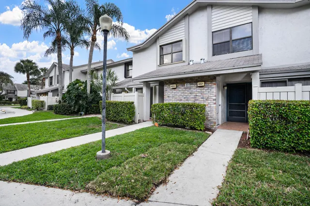 a front view of a house with a garden and yard
