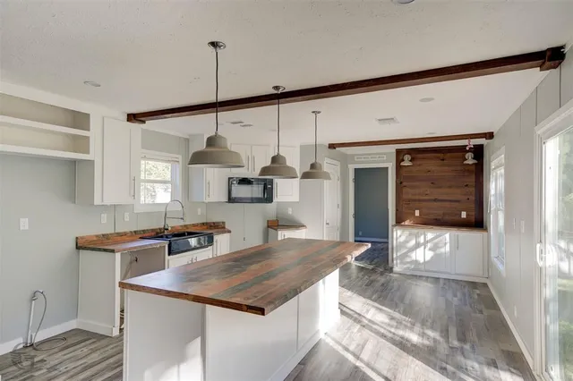 a kitchen with stainless steel appliances granite countertop a sink a stove and a wooden floors