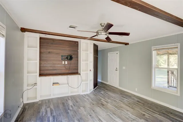 a view of a hallway with wooden floor and a window
