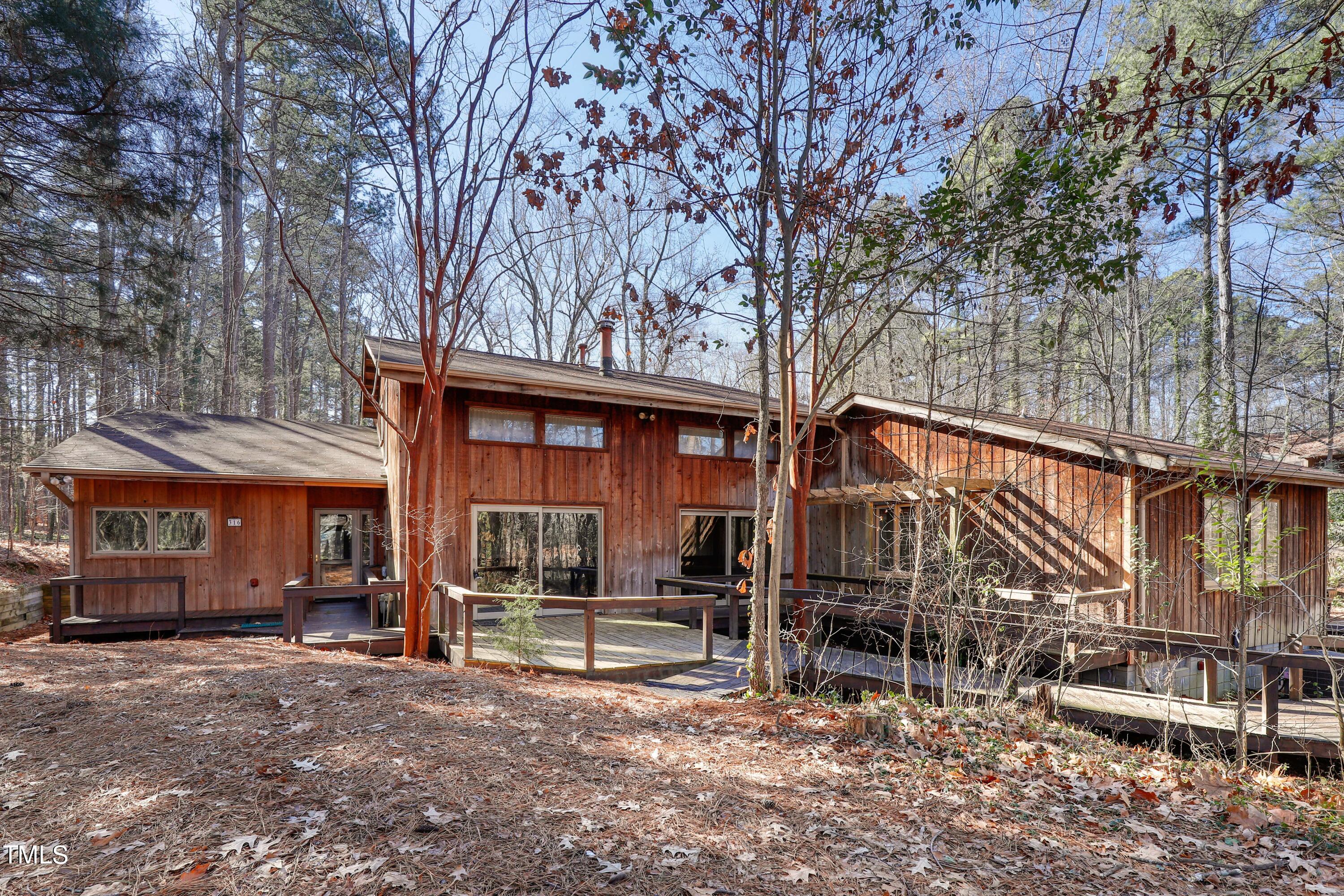 316 Clark Lake Road Durham, NC 27707 - Photo 1 of 65 a backyard of a house with wooden fence and large trees