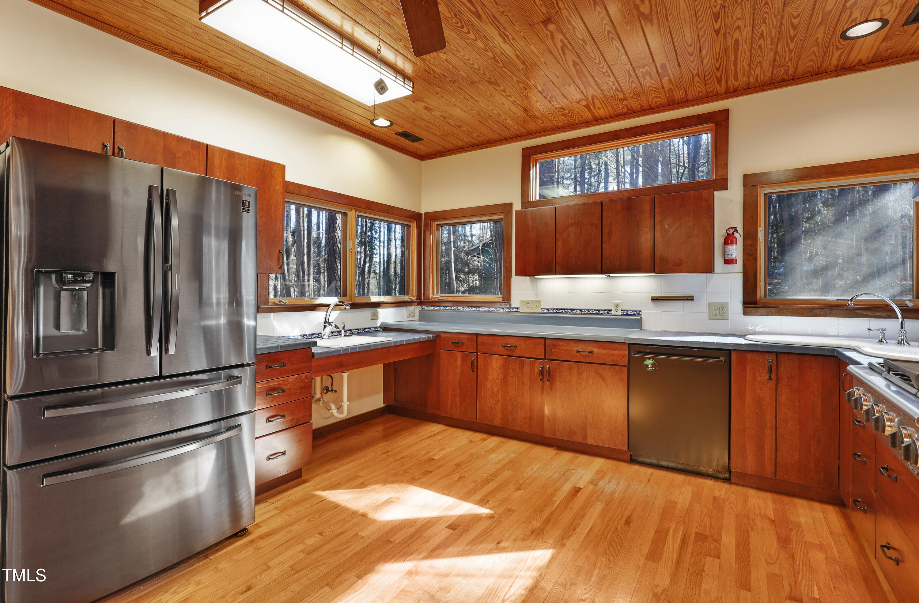316 Clark Lake Road Durham, NC 27707 - Photo 13 of 65 a kitchen with stainless steel appliances granite countertop a refrigerator a sink dishwasher a stove with wooden cabinets and floor