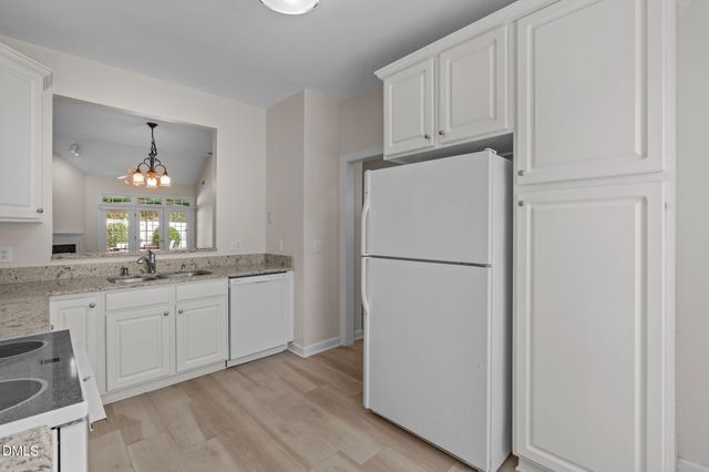 a kitchen with kitchen island white cabinets and refrigerator