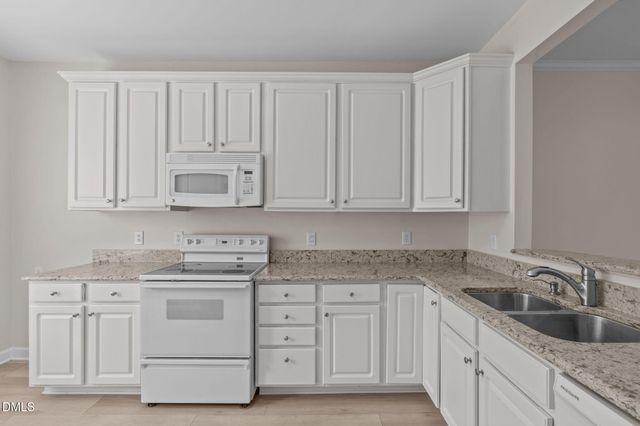 a kitchen with white cabinets and white appliances