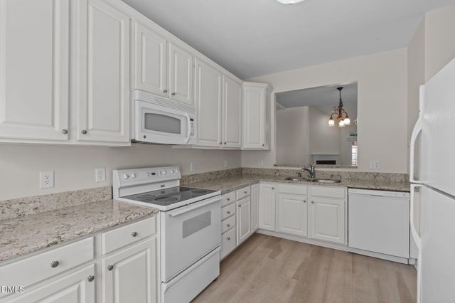 a kitchen with granite countertop white cabinets and a sink