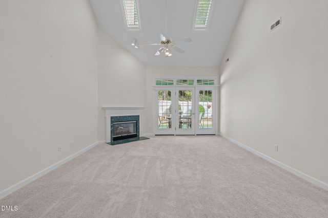 an empty room with windows and fireplace