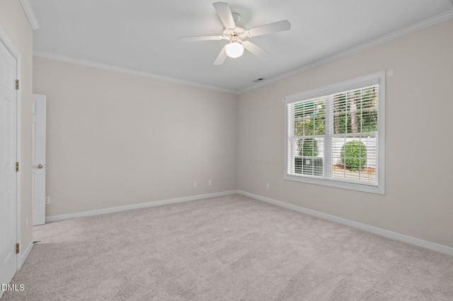 an empty room with a window and a fan