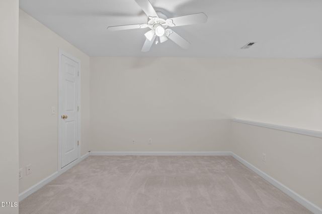 an empty room with a fan & a ceiling fan
