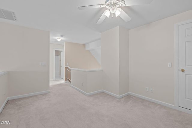 an empty room with a ceiling fan and entryway