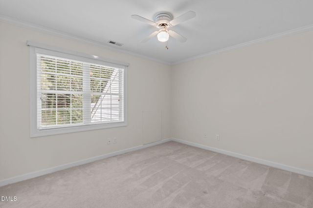 an empty room with a window and a ceiling fan