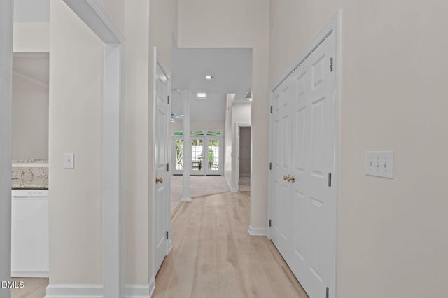 a view of a hallway with wooden floor and a bathroom