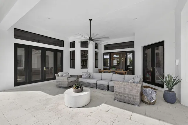 a large white kitchen with lots of counter space a sink and stainless steel appliances