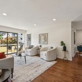 a living room with furniture floor to ceiling window and a table