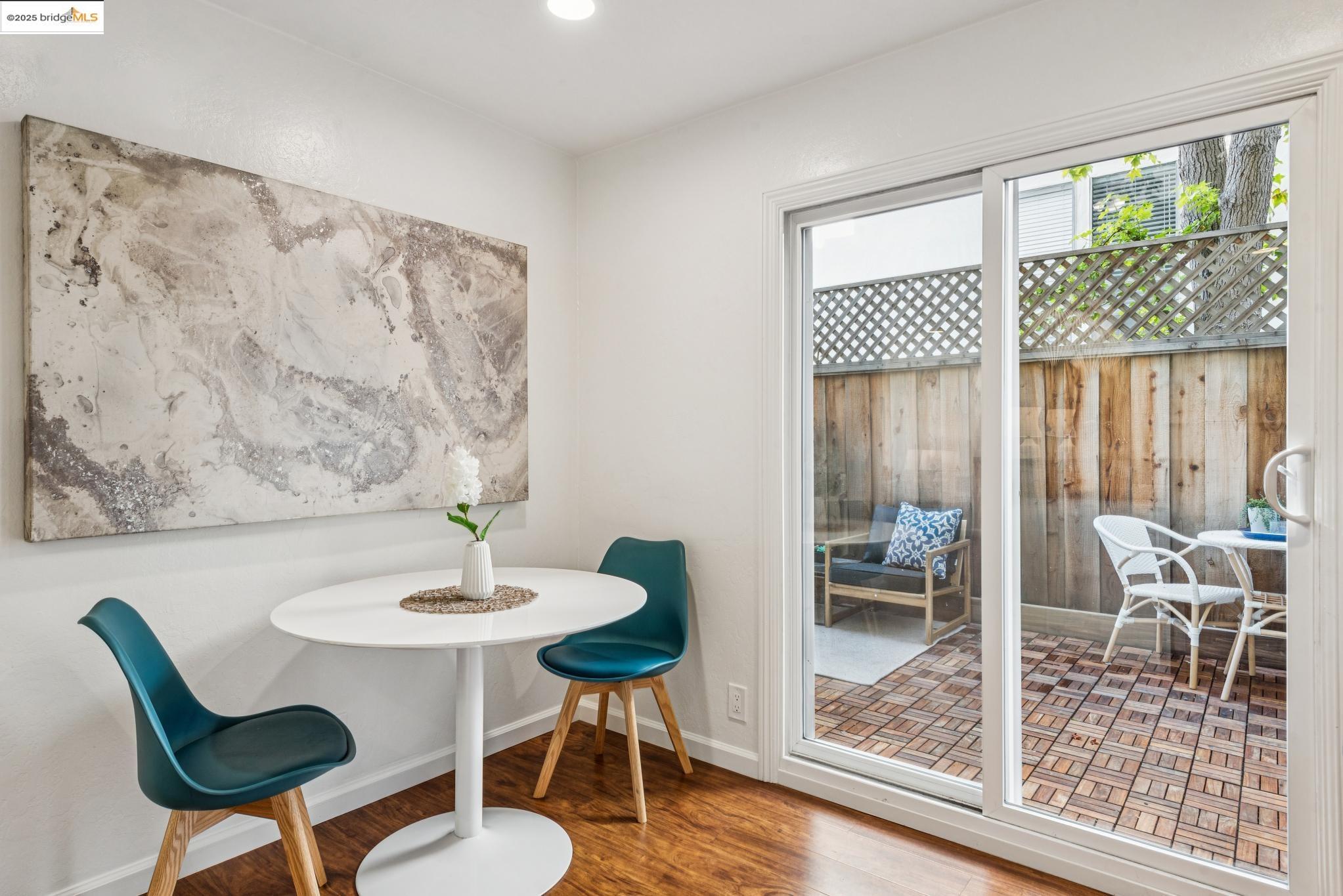 651 Oakland Avenue, Unit 1E Oakland, CA 94611 - Photo 11 of 28 a dining room with wooden floor and a table