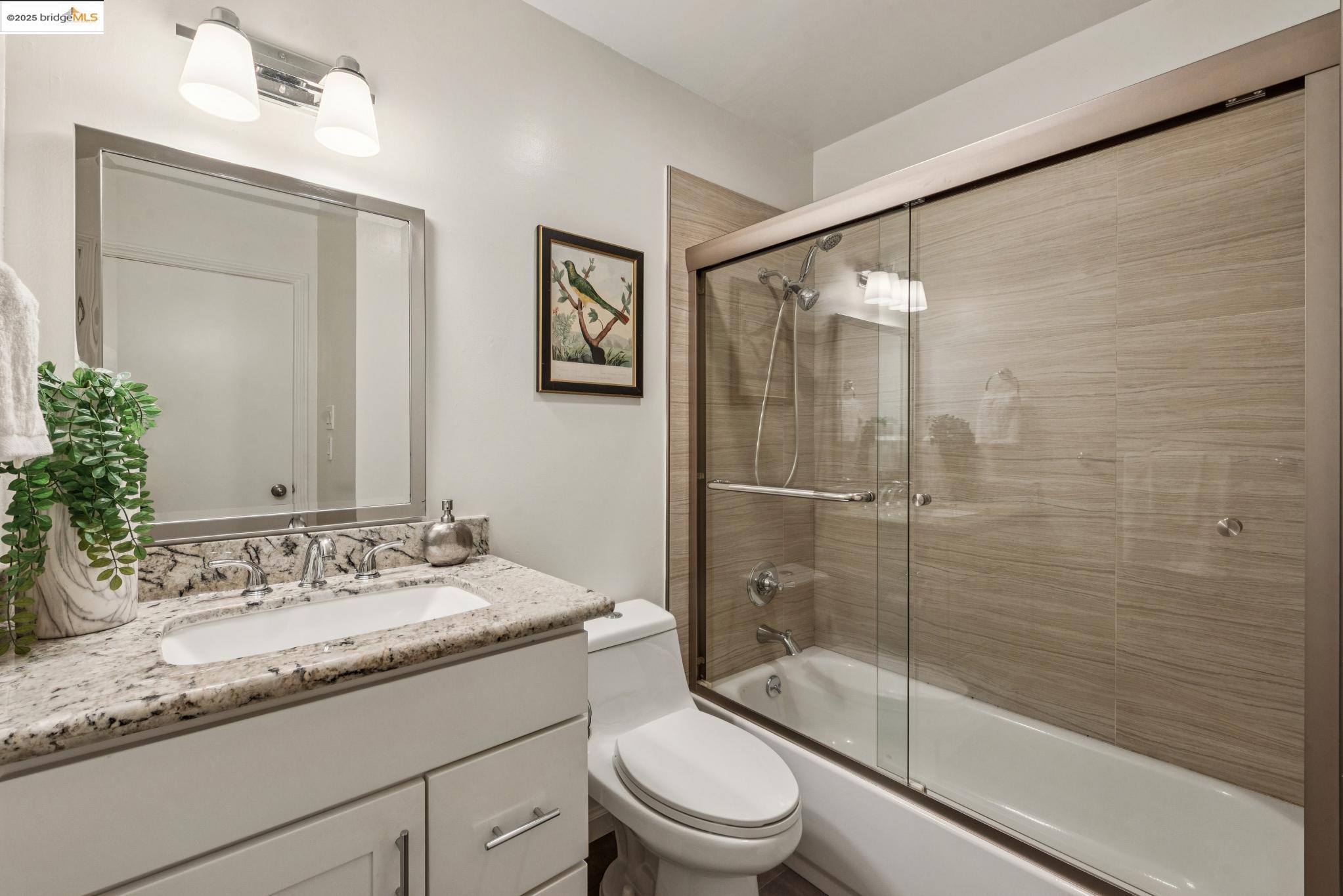 651 Oakland Avenue, Unit 1E Oakland, CA 94611 - Photo 14 of 28 a bathroom with a granite countertop sink toilet and shower