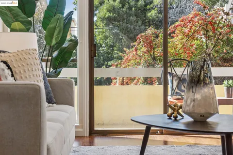 a view of a balcony with chairs and a potted plant
