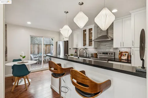 a living room with furniture kitchen view and a large mirror