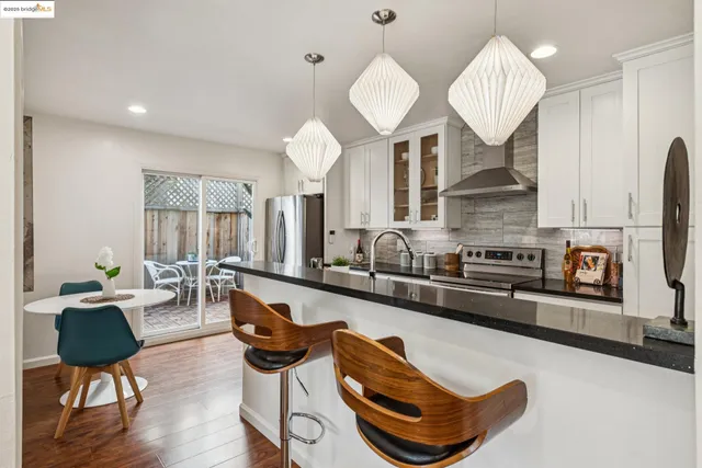 a living room with furniture kitchen view and a large mirror