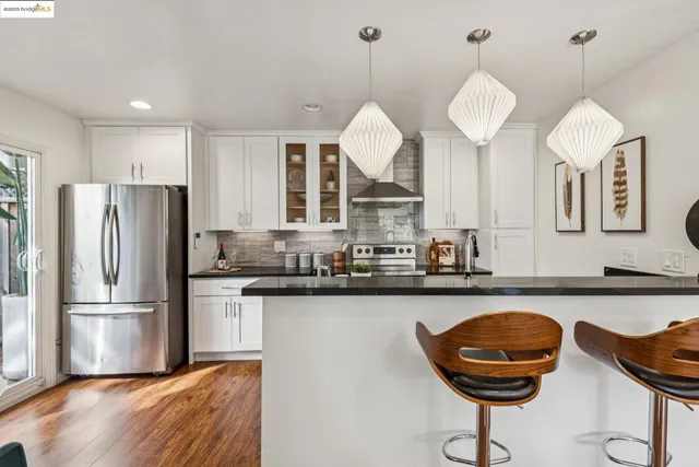 a kitchen with stainless steel appliances granite countertop a sink a stove and refrigerator