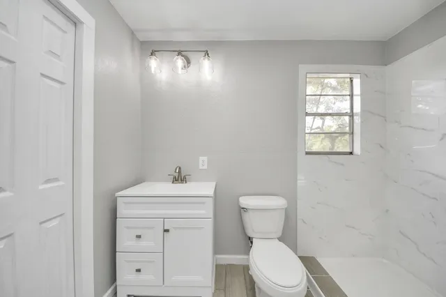 a bathroom with a toilet sink and mirror