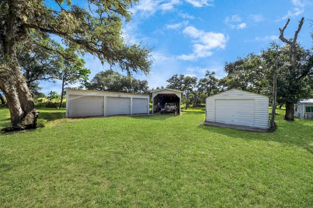 a view of an house with backyard space and a tree